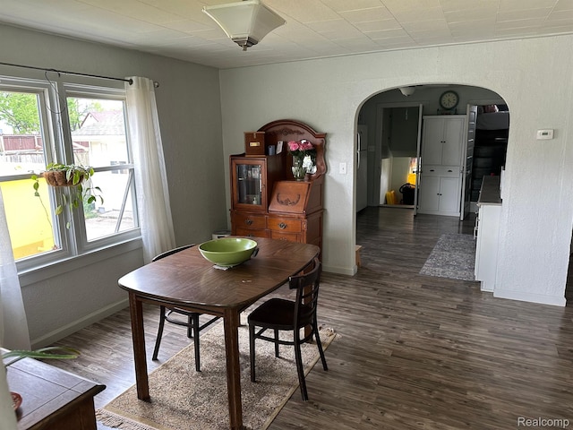 7980 W Gilford Rd, Reese, MI 48757 - dining area with arched walkways, dark wood finished floors, and a textured wall