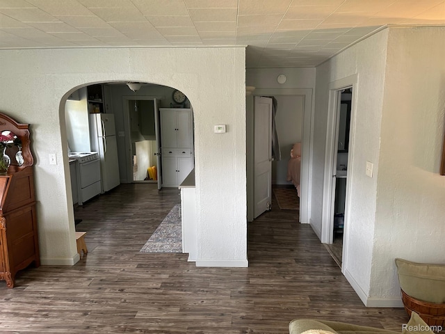 7980 W Gilford Rd, Reese, MI 48757 - hall with arched walkways, a textured wall, and dark wood finished floors
