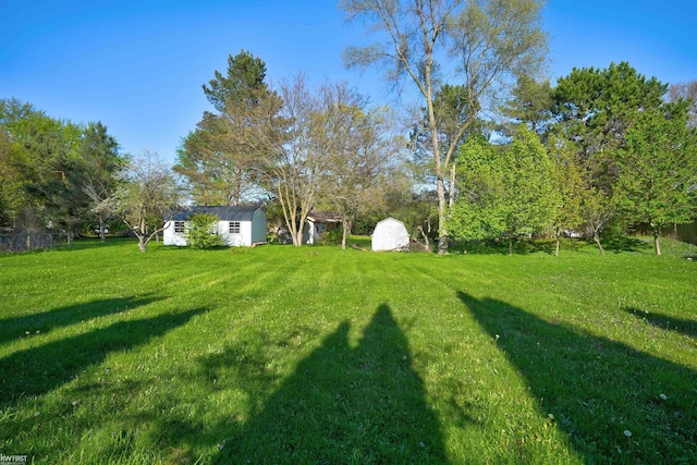 view of grassy yard with a storage unit and an outdoor structure