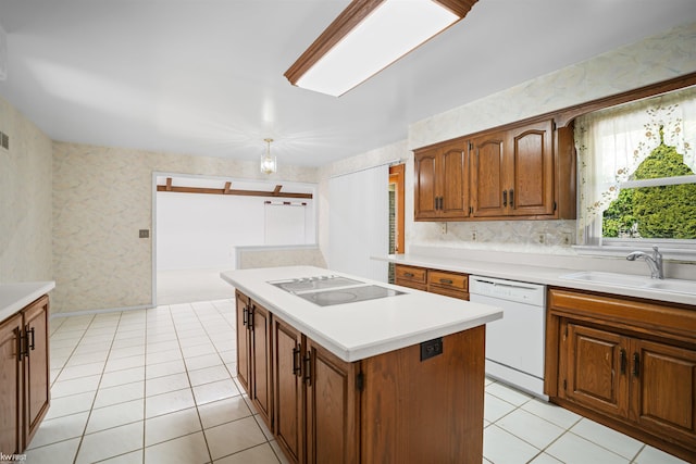 kitchen featuring white dishwasher, black electric cooktop, a sink, light countertops, and a kitchen island