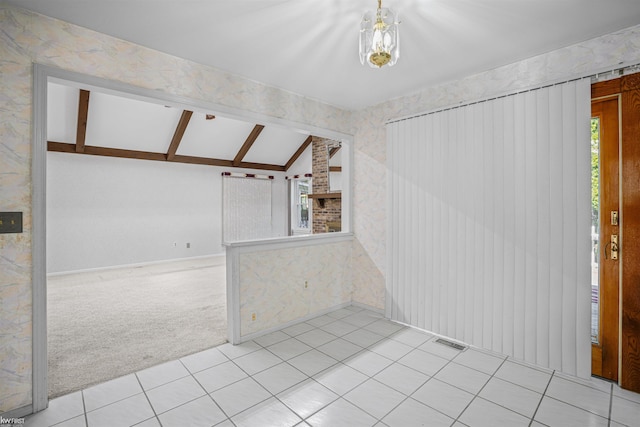 empty room with lofted ceiling, carpet, baseboards, and tile patterned flooring