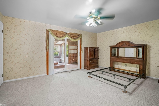 unfurnished bedroom featuring wallpapered walls, access to outside, carpet floors, baseboards, and a ceiling fan