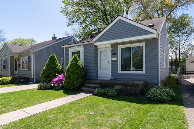 view of front of house featuring a front lawn and roof with shingles