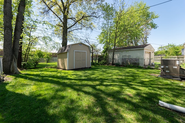 view of yard featuring an outbuilding, a storage unit, and central AC