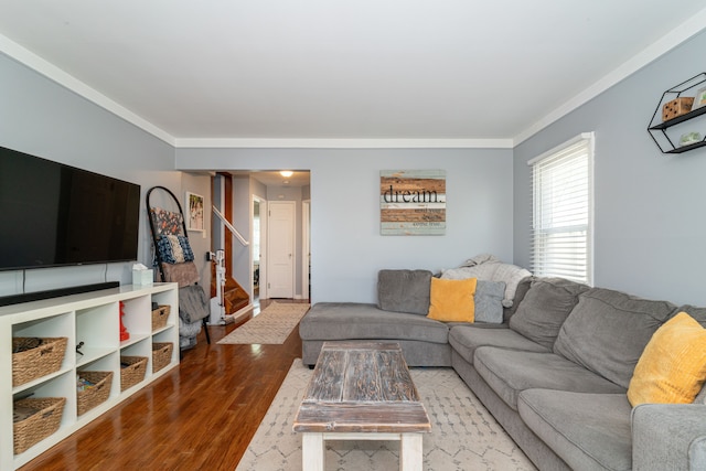 living room with ornamental molding, wood finished floors, and stairway