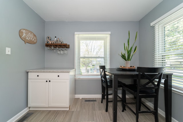 dining space featuring baseboards and light wood-style flooring