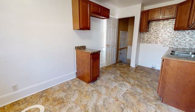 19720 Asbury Park, Detroit, MI 48235 - kitchen featuring a sink, decorative backsplash, baseboards, and brown cabinetry