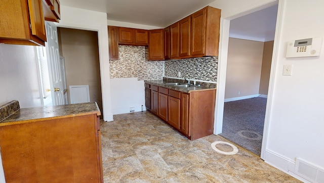 19720 Asbury Park, Detroit, MI 48235 - kitchen featuring a sink, brown cabinetry, tasteful backsplash, and dark countertops