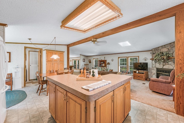 19251 Indian Dr, Paris, MI 49338 - kitchen featuring a fireplace, a textured ceiling, a kitchen island, open floor plan, and light countertops