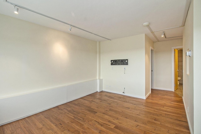 555 E William St Unit 25I, Ann Arbor, MI 48104 - unfurnished room featuring rail lighting, hardwood / wood-style floors, baseboards, and attic access