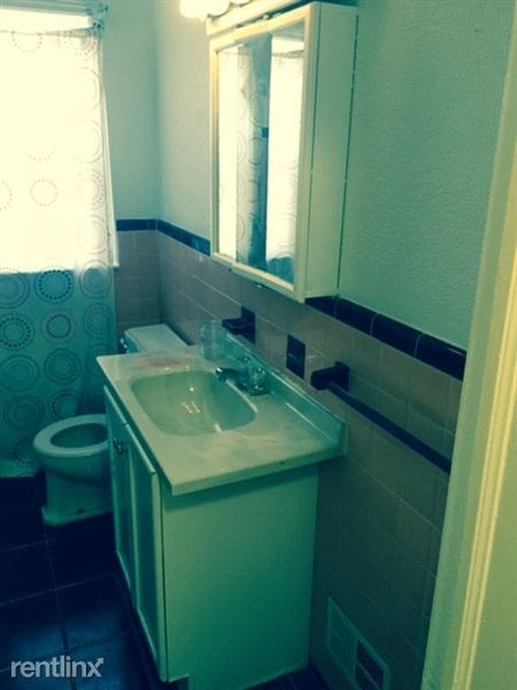 20244 Fairport St, Detroit, MI 48205 - bathroom with tile walls, vanity, toilet, and tile patterned flooring