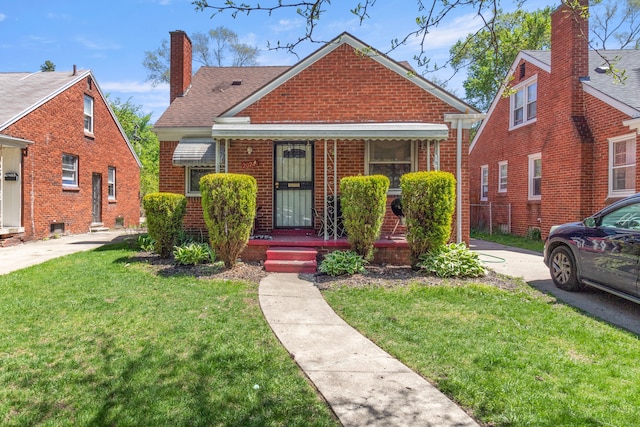 20244 Fairport St, Detroit, MI 48205 - bungalow featuring brick siding, a front yard, a chimney, covered porch, and a shingled roof