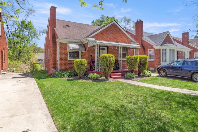 20244 Fairport St, Detroit, MI 48205 - bungalow-style house featuring brick siding, a chimney, a front yard, and a shingled roof