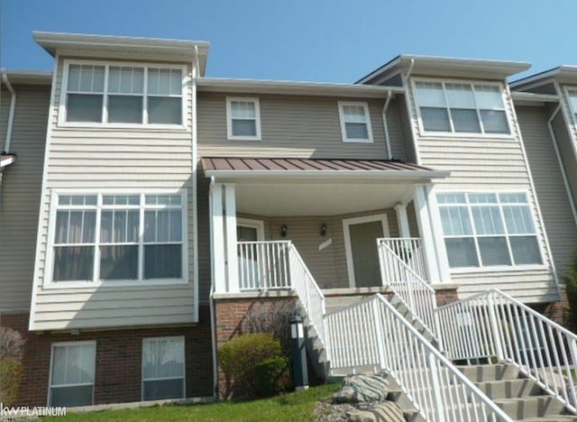11702 Weingartz E, Utica, MI 48315 - view of front of home with stairs, a standing seam roof, metal roof, brick siding, and a porch