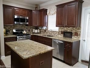 11702 Weingartz E, Utica, MI 48315 - kitchen featuring appliances with stainless steel finishes, tasteful backsplash, a sink, a kitchen island, and ornamental molding