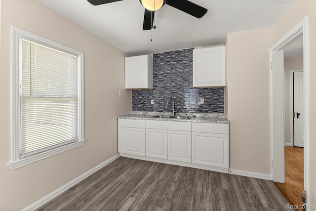 19327 Sunset St, Detroit, MI 48234 - kitchen featuring a sink, ceiling fan, dark wood-style flooring, decorative backsplash, and white cabinetry