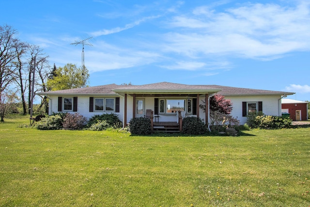 rear view of property featuring a lawn and a porch