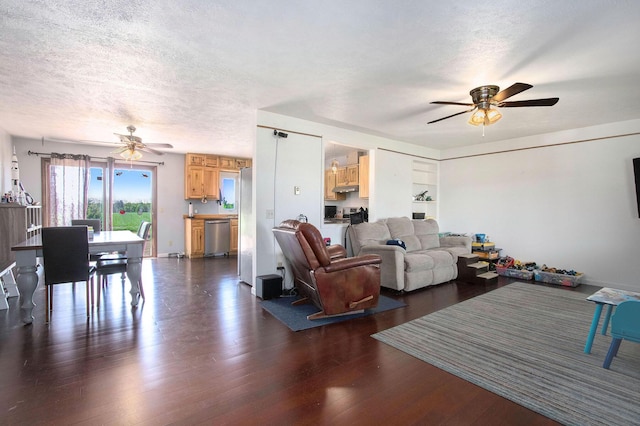 living area featuring ceiling fan, dark wood finished floors, and a textured ceiling