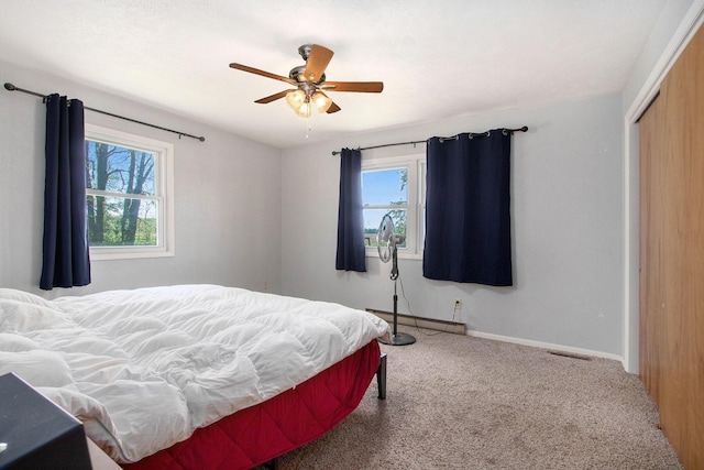 bedroom with multiple windows, carpet flooring, a closet, and baseboards