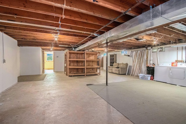unfinished below grade area featuring washing machine and clothes dryer