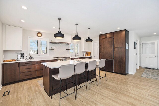 55 Gabriel Dr, South Haven, MI 49090 - kitchen featuring recessed lighting, light wood finished floors, light countertops, a kitchen bar, and a sink