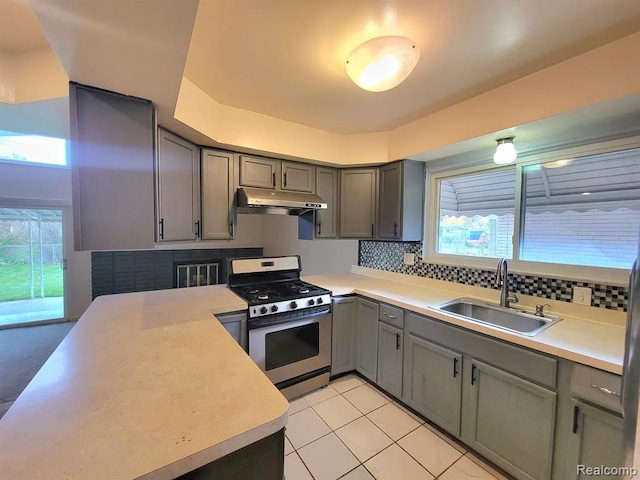 28142 Liberty Dr, Warren, MI 48092 - kitchen with a sink, stainless steel gas stove, gray cabinets, under cabinet range hood, and light countertops