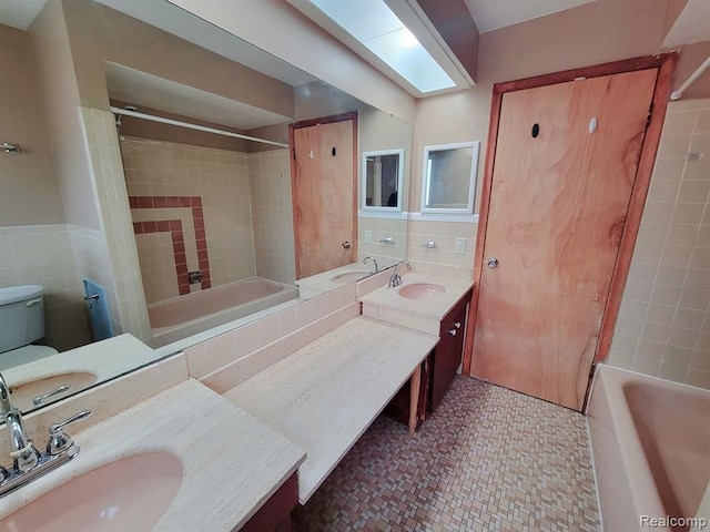 28142 Liberty Dr, Warren, MI 48092 - bathroom with tile walls, vanity, toilet, bathing tub / shower combination, and a wainscoted wall