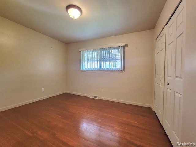 28142 Liberty Dr, Warren, MI 48092 - unfurnished bedroom with dark wood-type flooring, baseboards, and a closet