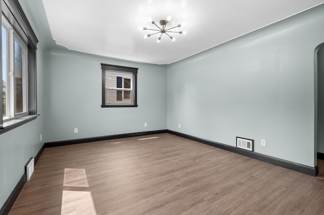 137 Wiltshire Ave, Battle Creek, MI 49015 - unfurnished room featuring a chandelier, wood finished floors, and arched walkways