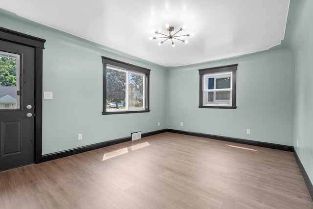 137 Wiltshire Ave, Battle Creek, MI 49015 - unfurnished room with a chandelier and wood finished floors