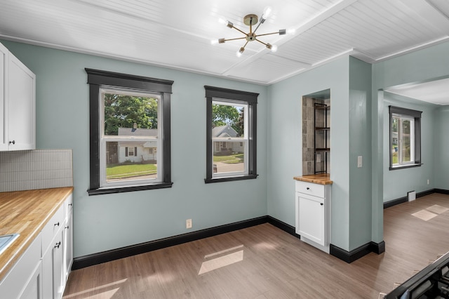 137 Wiltshire Ave, Battle Creek, MI 49015 - kitchen with wood counters, light wood finished floors, white cabinetry, and a chandelier