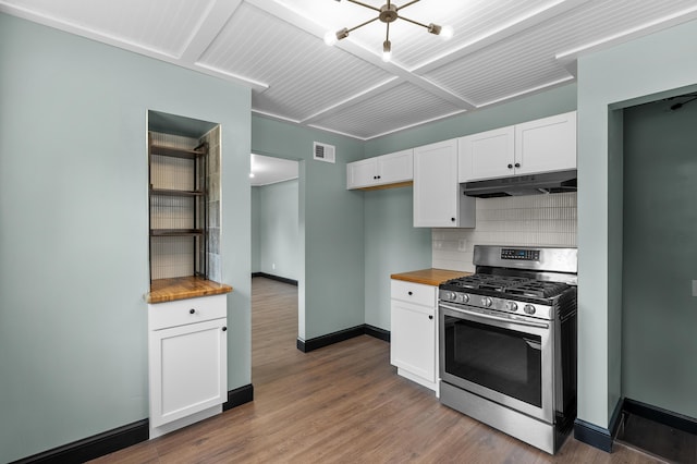 137 Wiltshire Ave, Battle Creek, MI 49015 - kitchen with stainless steel range with gas stovetop, under cabinet range hood, butcher block counters, backsplash, and white cabinetry