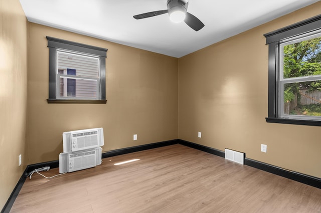 137 Wiltshire Ave, Battle Creek, MI 49015 - empty room featuring wood finished floors, ceiling fan, an AC wall unit, and a wall mounted air conditioner