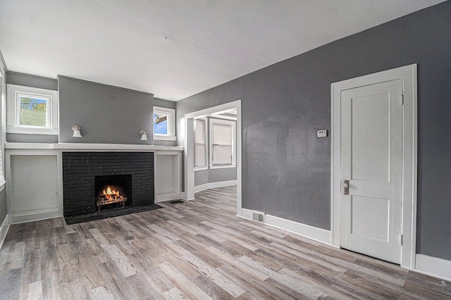 208 Hill St, Highland Park, MI 48203 - unfurnished living room featuring a brick fireplace, wood finished floors, and baseboards