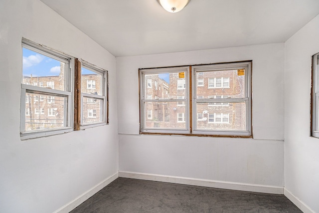 208 Hill St, Highland Park, MI 48203 - spare room with baseboards and dark colored carpet
