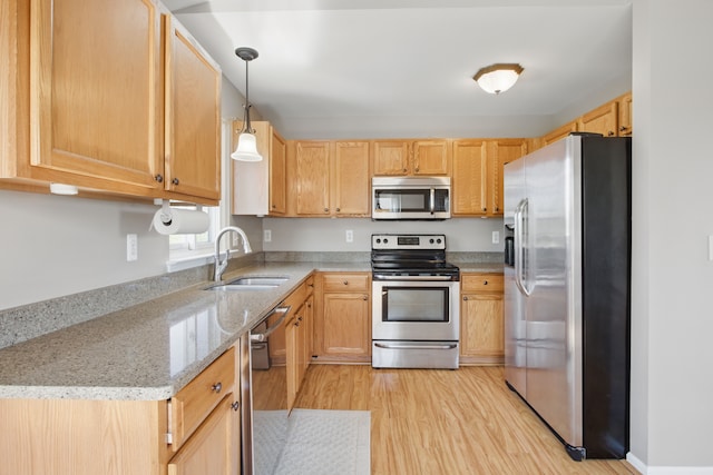 4127 Stone Post Rd, Newport, MI 48166 - kitchen featuring stainless steel appliances, a sink, light wood finished floors, light stone counters, and light brown cabinets