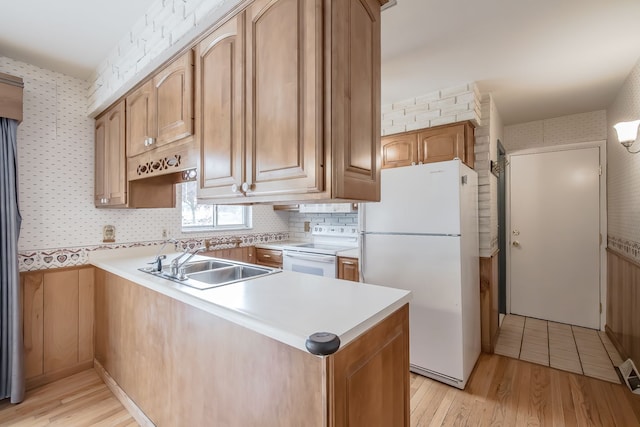 841 Driburg Dr, Commerce Twp, MI 48390 - kitchen with white appliances, a sink, light wood-style floors, a peninsula, and wallpapered walls