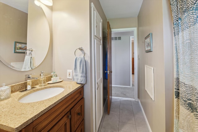 bathroom featuring tile patterned floors, baseboards, and vanity