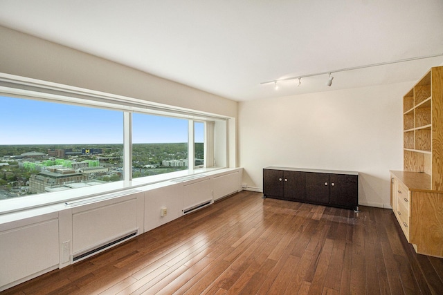 555 E William St Unit 25J, Ann Arbor, MI 48104 - empty room with track lighting, hardwood / wood-style floors, and a baseboard heating unit