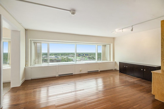 555 E William St Unit 25J, Ann Arbor, MI 48104 - spare room featuring track lighting, plenty of natural light, wood-type flooring, and a smoke detector