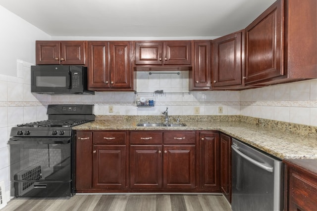 10436 Bertram St, Dearborn, MI 48126 - kitchen with black appliances, a sink, light wood-style flooring, and light stone counters