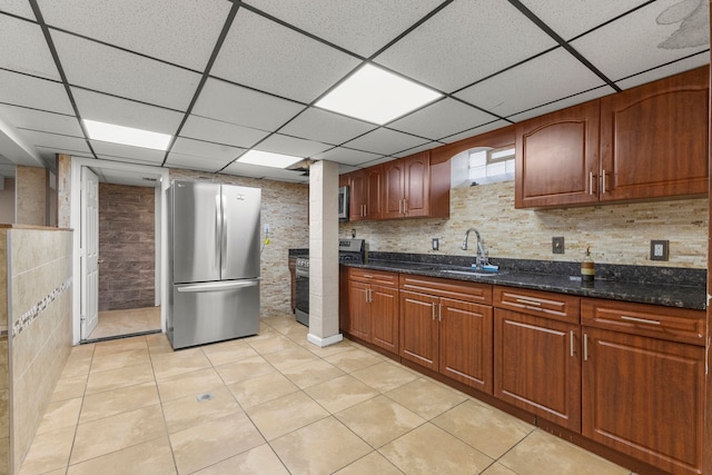 10436 Bertram St, Dearborn, MI 48126 - kitchen featuring stainless steel appliances, a sink, a drop ceiling, light tile patterned floors, and dark stone countertops