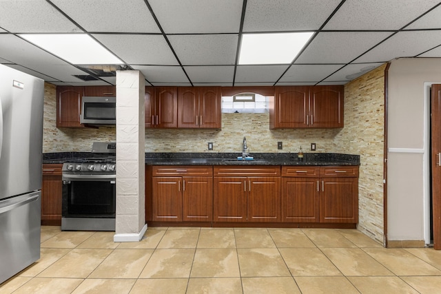 10436 Bertram St, Dearborn, MI 48126 - kitchen with appliances with stainless steel finishes, a sink, light tile patterned flooring, a paneled ceiling, and dark stone countertops