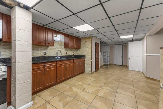 10436 Bertram St, Dearborn, MI 48126 - kitchen featuring light tile patterned floors, dark stone countertops, a drop ceiling, a sink, and backsplash