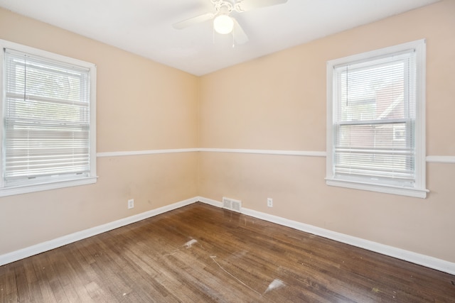 empty room with wood finished floors, baseboards, and ceiling fan