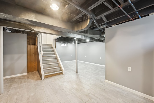 finished below grade area with stairway, baseboards, and wood finished floors
