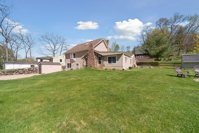 5780 Elvira, Pinckney, MI 48169 - view of front of house with a front lawn, a chimney, a storage unit, and an outdoor structure
