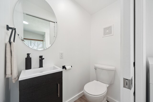 5780 Elvira, Pinckney, MI 48169 - bathroom featuring toilet, baseboards, vanity, and wood finished floors