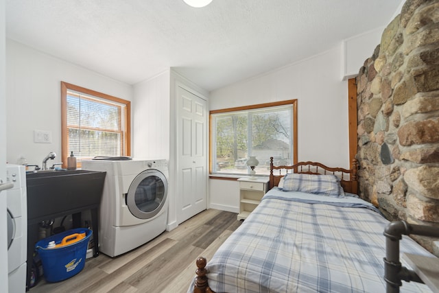 5780 Elvira, Pinckney, MI 48169 - bedroom featuring washer / dryer, light wood-style floors, and a textured ceiling