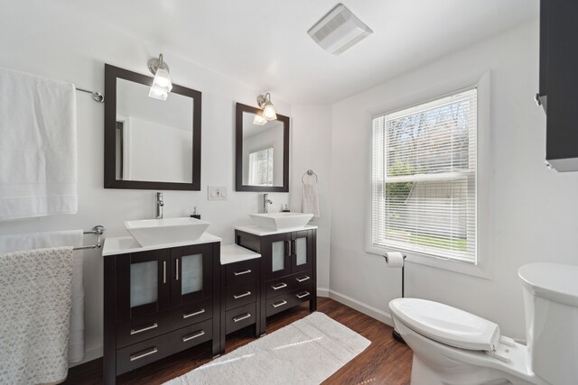 5780 Elvira, Pinckney, MI 48169 - full bath featuring toilet, wood finished floors, two vanities, and baseboards